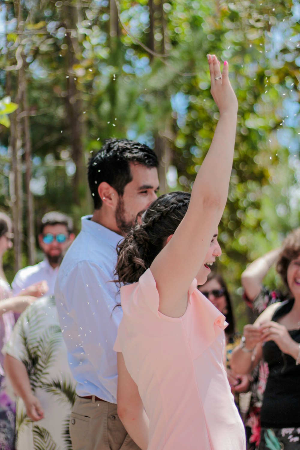 man in pink polo shirt raising his hands