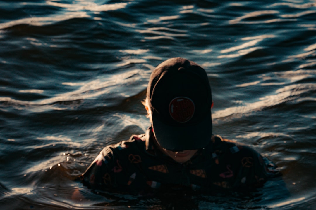 person in black and white hoodie wearing black and white goggles in water
