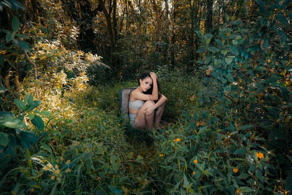 woman in black tank top sitting on green grass field during daytime