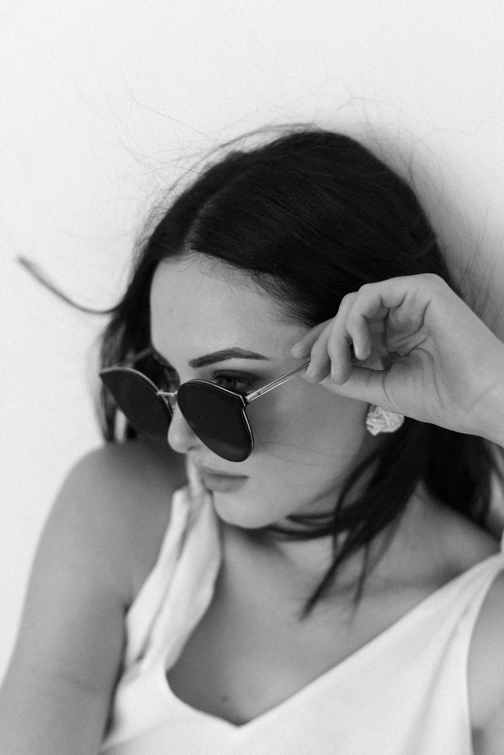 woman wearing black sunglasses and white tank top