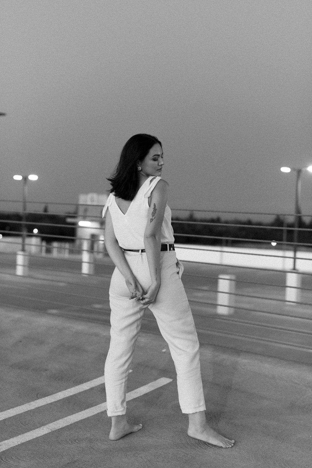 woman in white long sleeve shirt and white pants standing on road