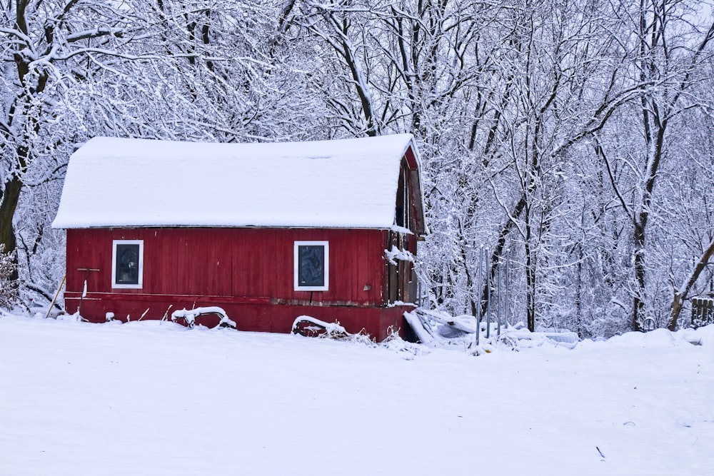 rot-weiße Holzscheune auf schneebedecktem Boden