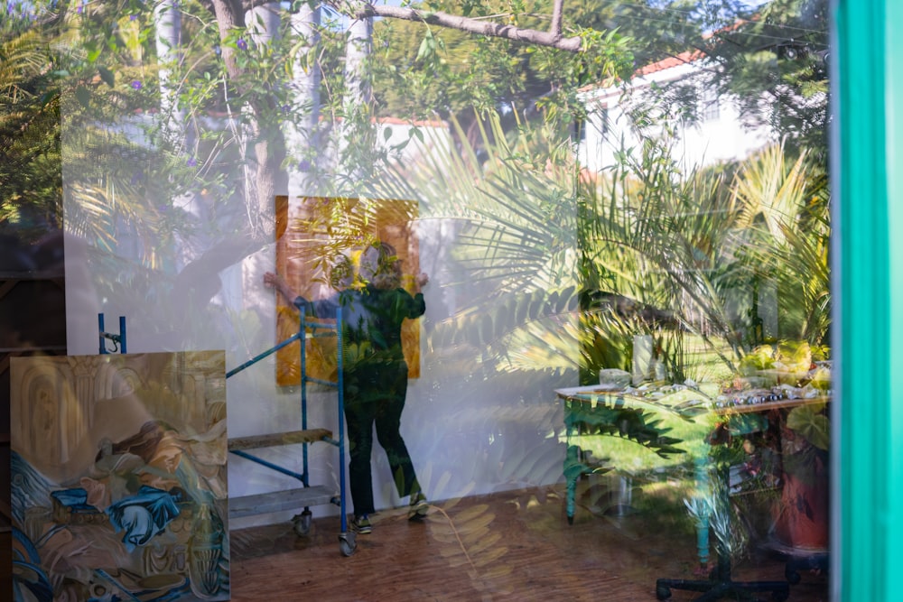 woman in green and yellow dress standing beside green palm plant