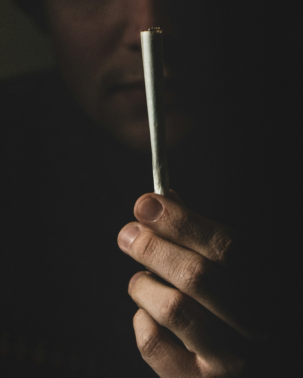 person holding white cigarette stick