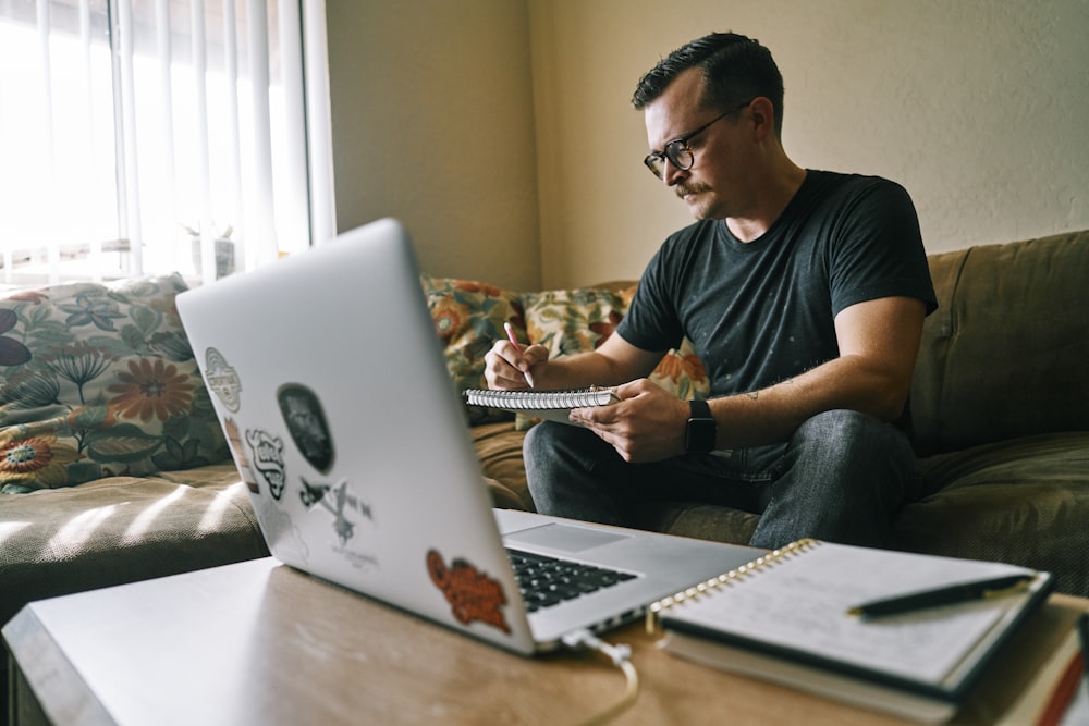 man in black crew neck t-shirt using macbook