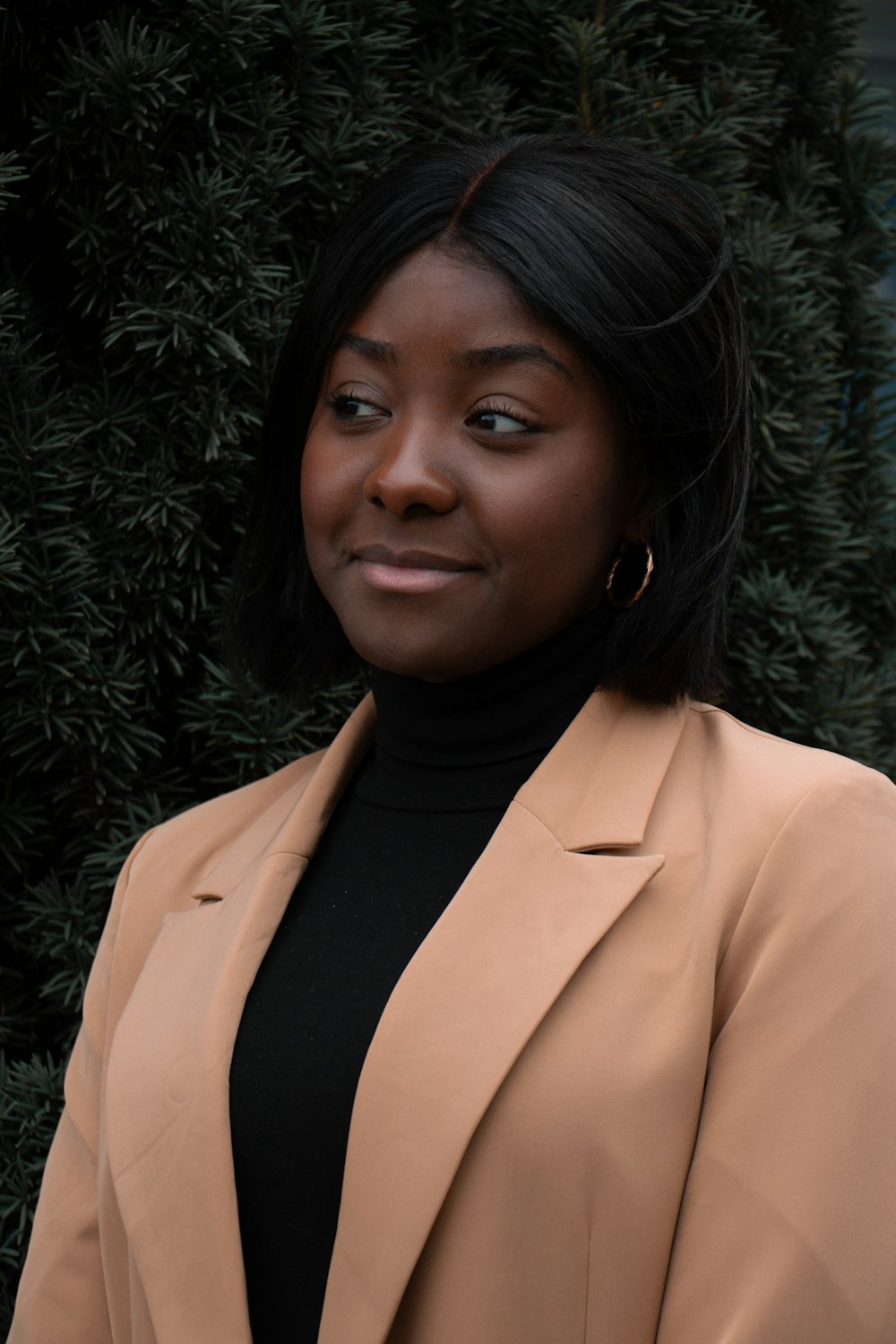 woman in beige coat smiling