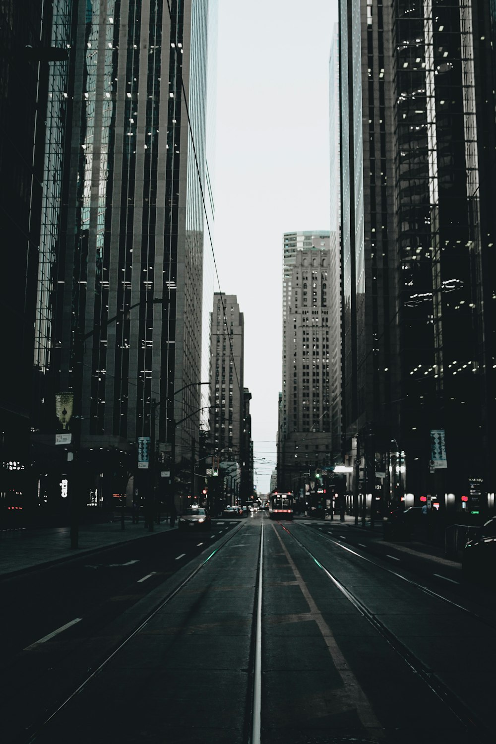 cars on road between high rise buildings during daytime