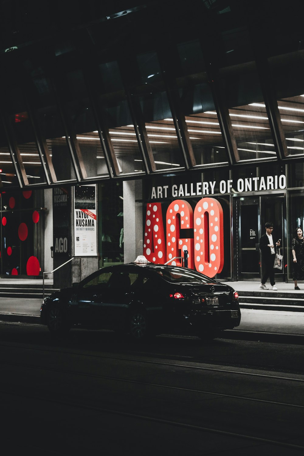 black sedan on road near red and white building during night time