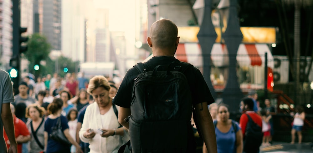 Mann in schwarzem T-Shirt mit schwarzem Rucksack