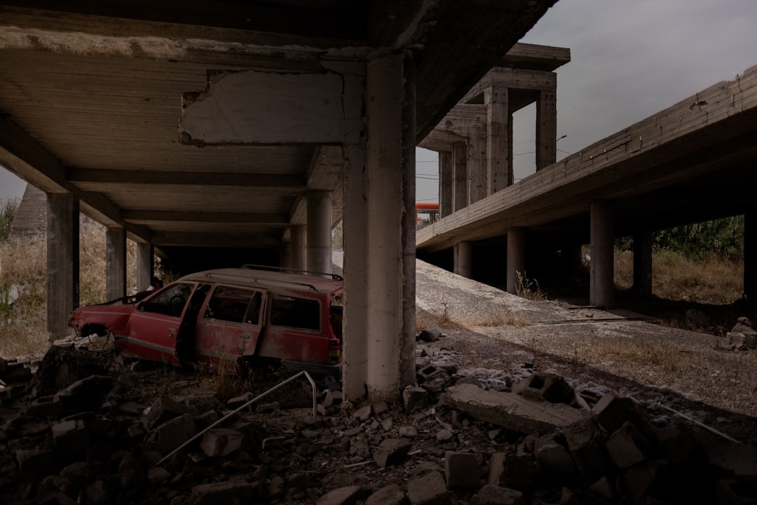 red car under bridge during daytime