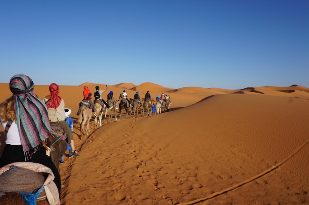 personnes marchant sur le désert pendant la journée