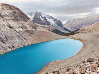 blue lake surrounded by rocky mountains during daytime