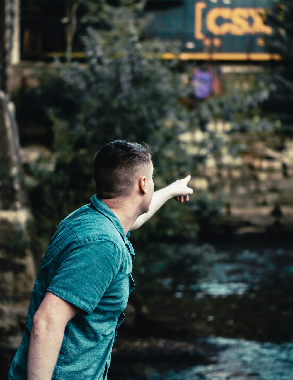 man in blue t-shirt standing near body of water during daytime