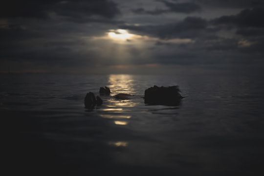 silhouette of rocks on water during sunset in Batangas Philippines