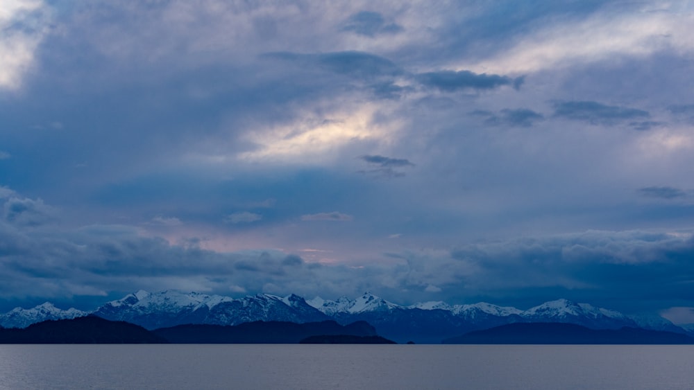 snow covered mountain under cloudy sky during daytime