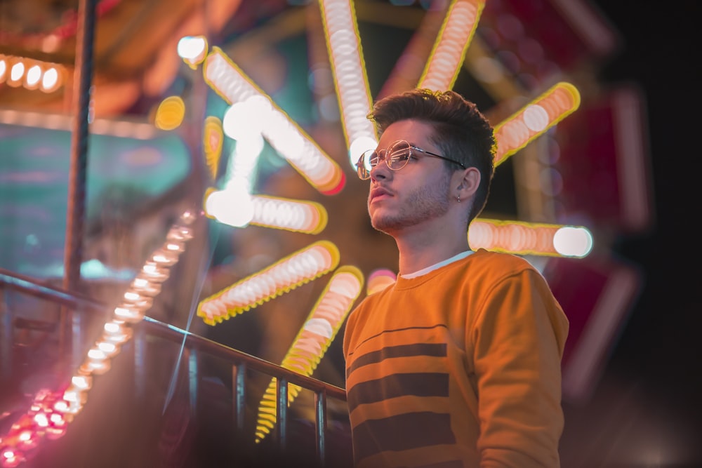 man in orange and black striped crew neck shirt wearing black framed eyeglasses