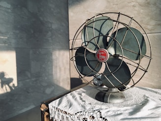 black desk fan on white and black floral table cloth