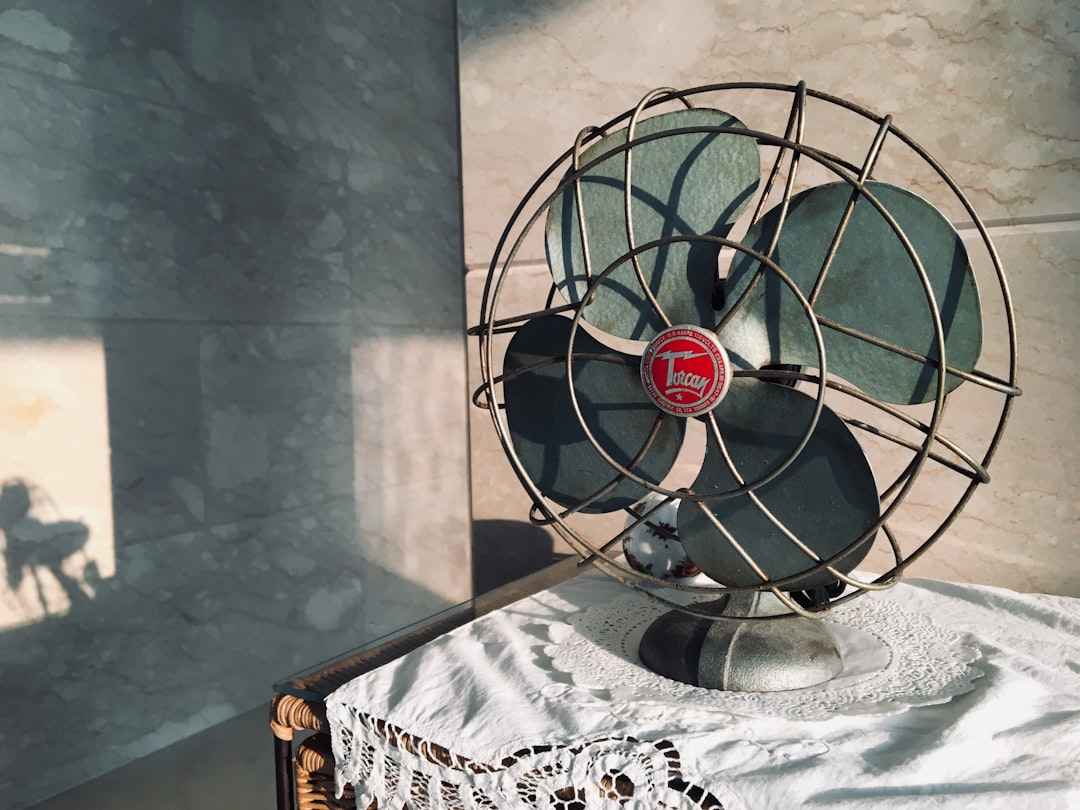  black desk fan on white and black floral table cloth fan