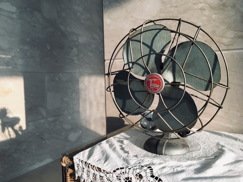 black desk fan on white and black floral table cloth