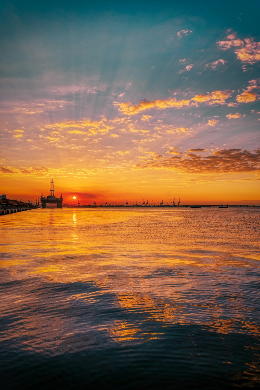 silhouette of building near body of water during sunset