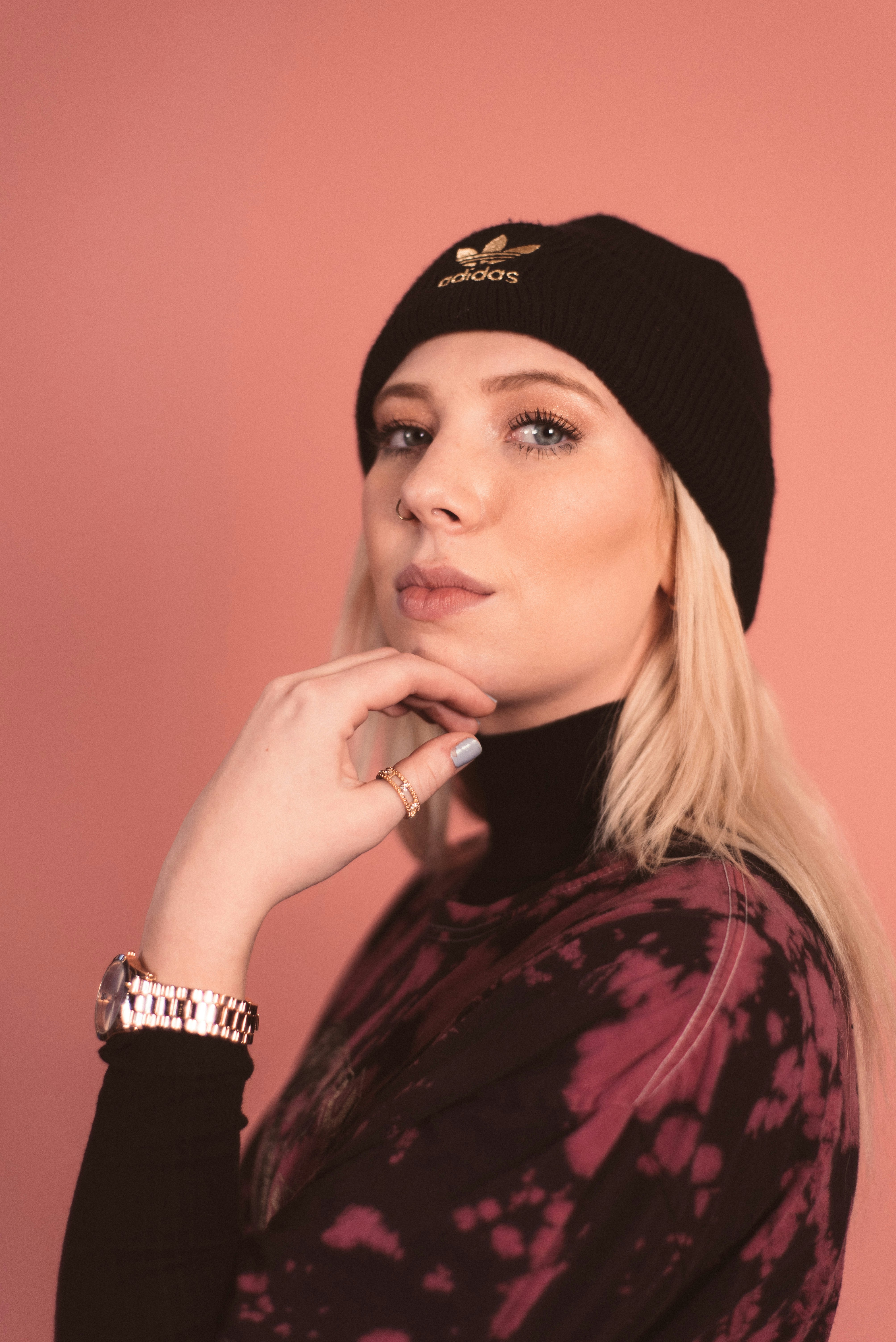 Frau mit schwarzer Strickmütze und schwarz-rotem geblümtem Langarmshirt