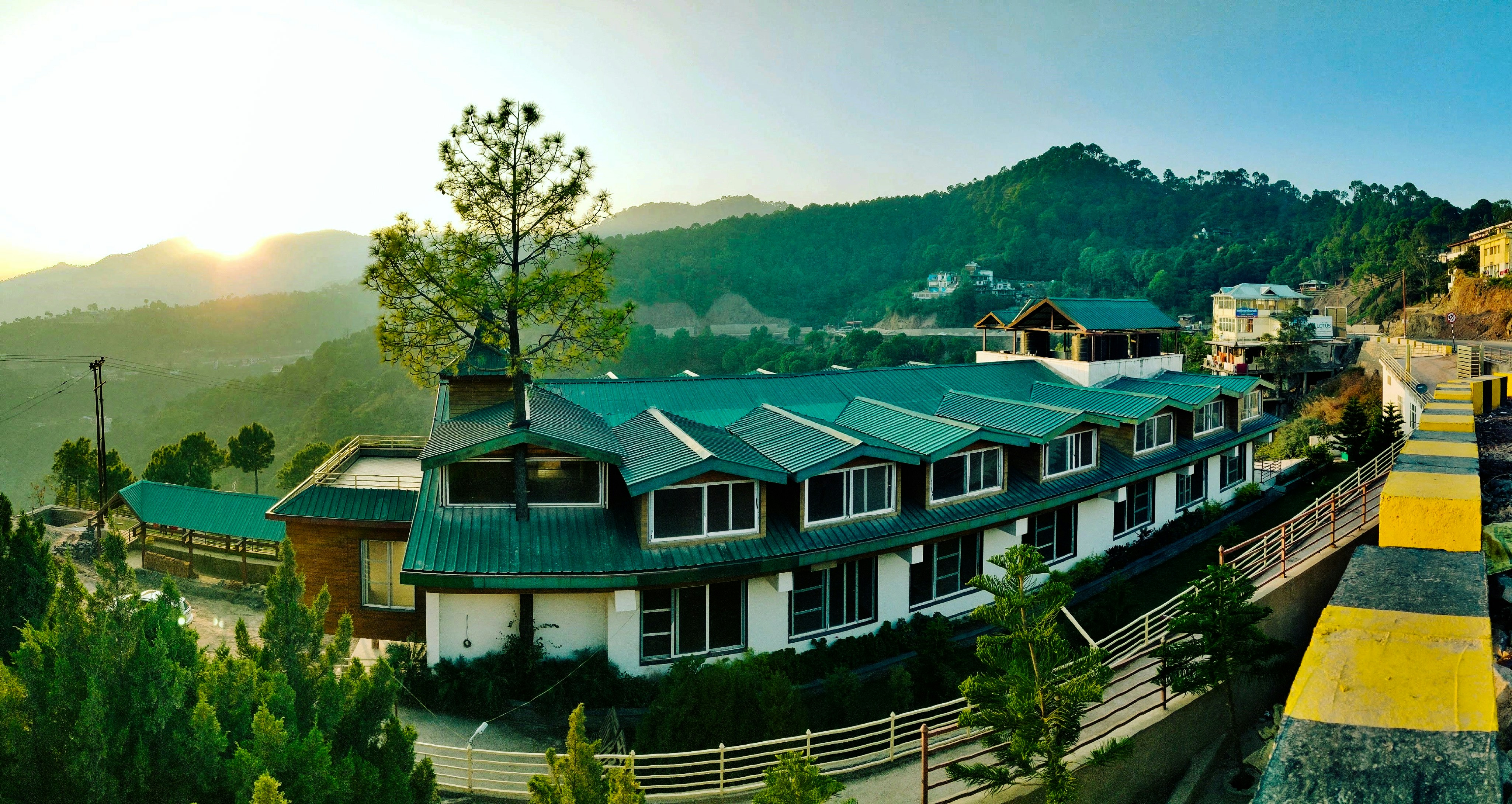 Boutique hotel exterior with solar panels on roof surrounded by trees in mountain setting