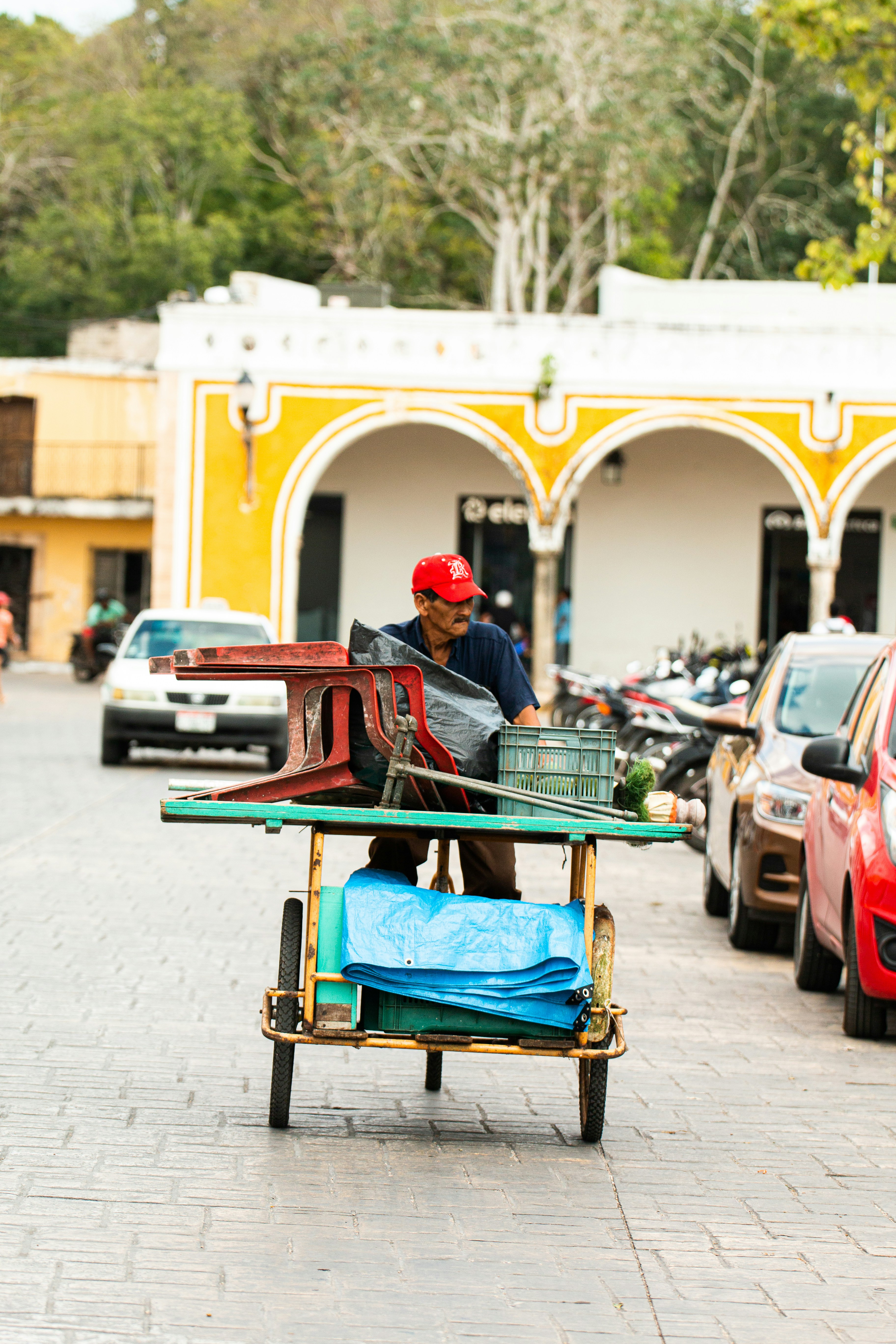 Hombre con camisa roja sentado en un banco de madera rojo y blanco durante el día