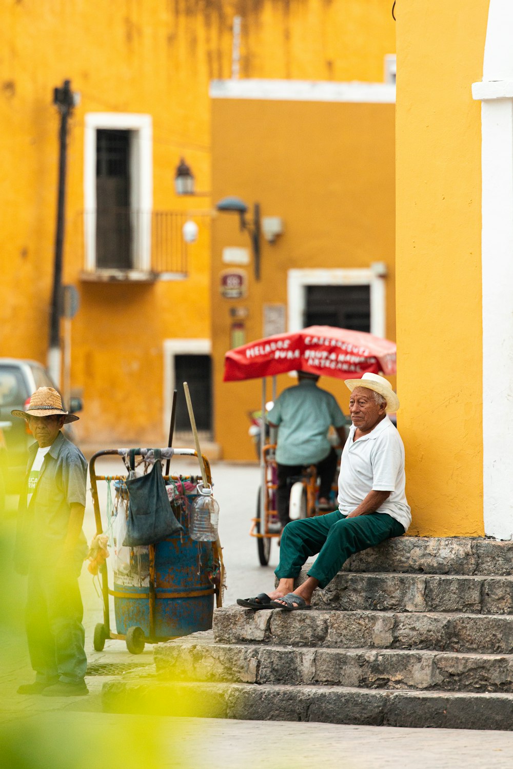 man in white long sleeve shirt sitting on concrete stairs during daytime