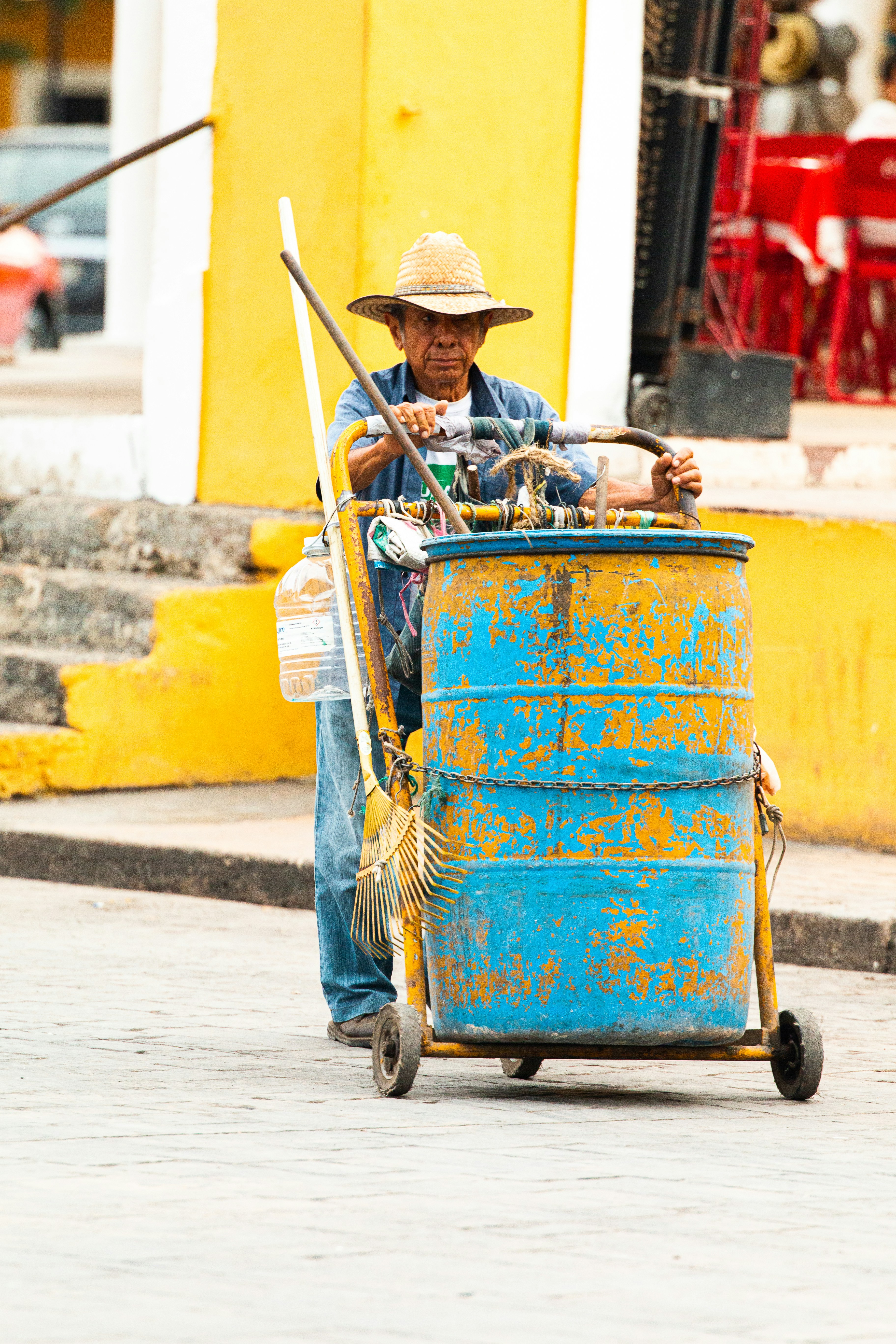 Hombre con sombrero marrón montando carro azul y amarillo