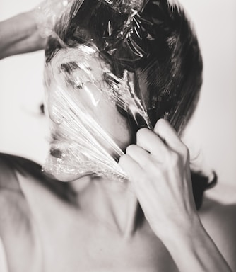 woman covering face with white textile