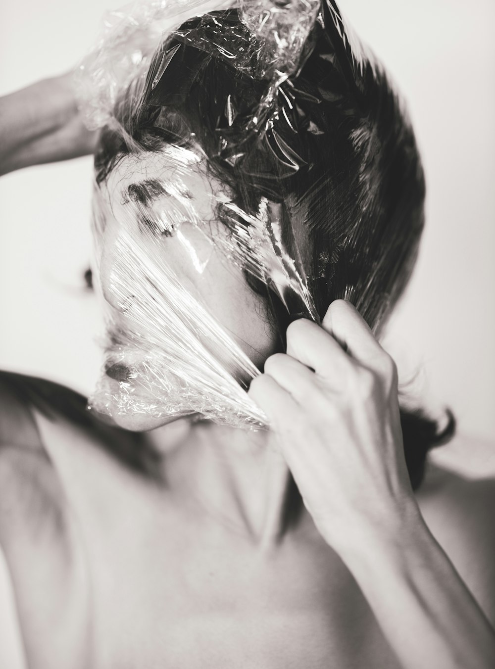 woman covering face with white textile