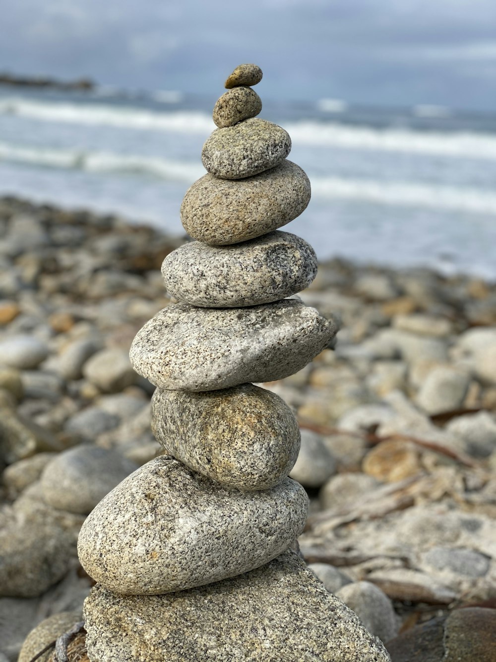 Empilement de pierres grises et blanches près de la mer pendant la journée