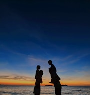 silhouette of man and woman kissing during sunset