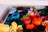 A basket filled with neatly arranged rolls of colorful felt fabric. The fabrics are rolled tightly and organized by color, creating a vibrant and visually appealing display. Shades range from blues and greens to reds, oranges, and yellows.