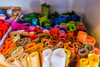 A vibrant display of handmade felt sheets in various colors.