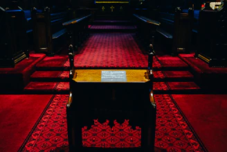 A somber scene showing a dimly lit church interior with empty pews, evoking reflection and solemnity.