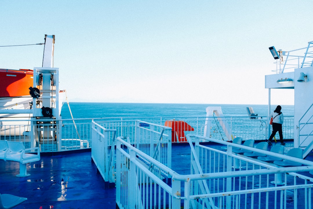 white and red wooden fence on blue sea during daytime