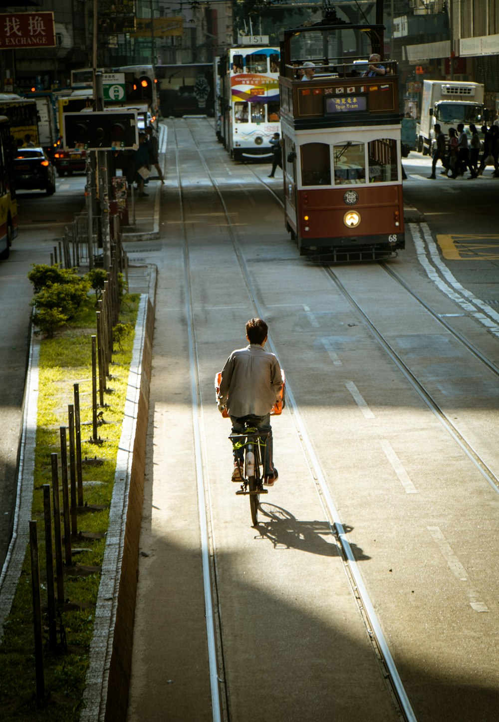 man in gray jacket riding bicycle on gray concrete road during daytime