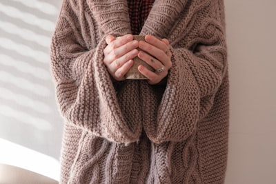 person in brown knit sweater sweater google meet background