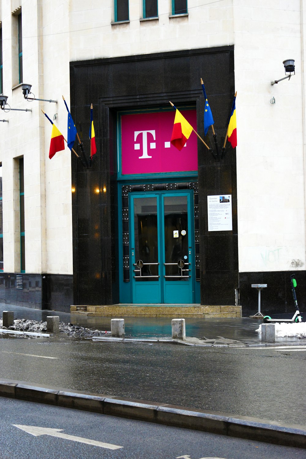 a tall building with a blue door and a pink sign