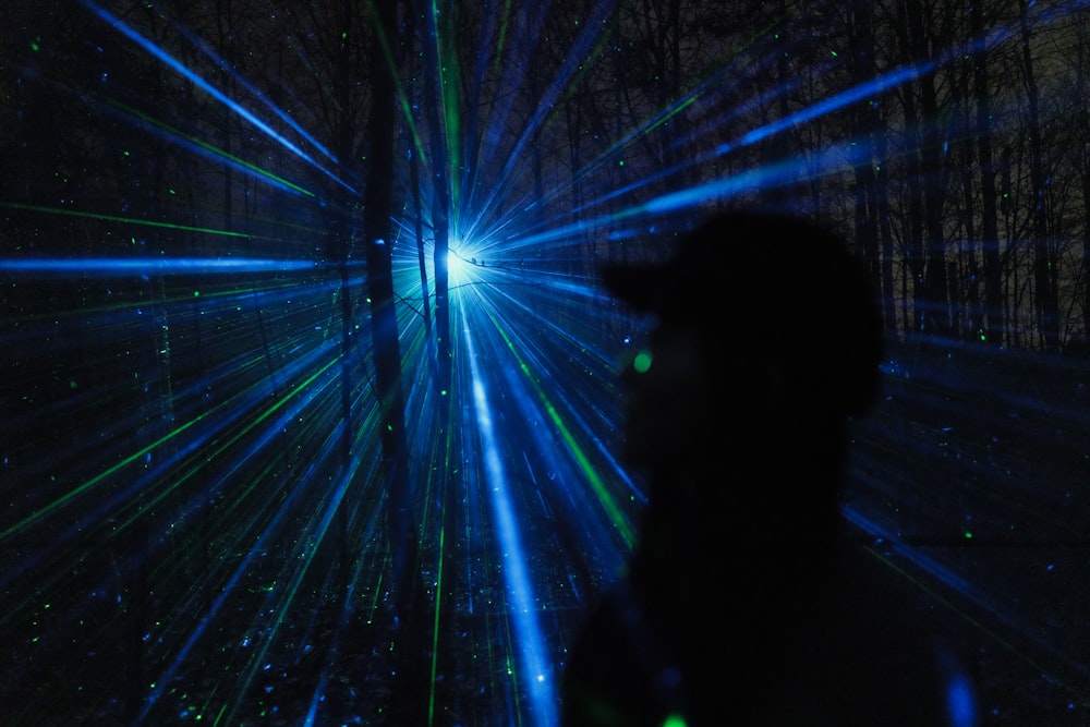 silhouette of man standing in front of blue light