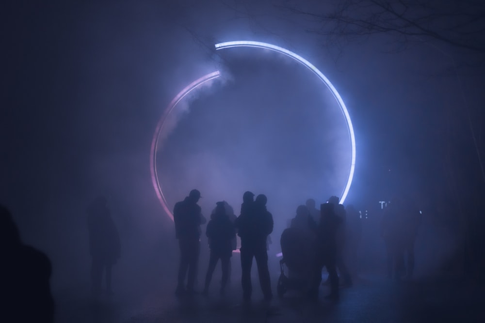 silhouette of people standing on forest with light