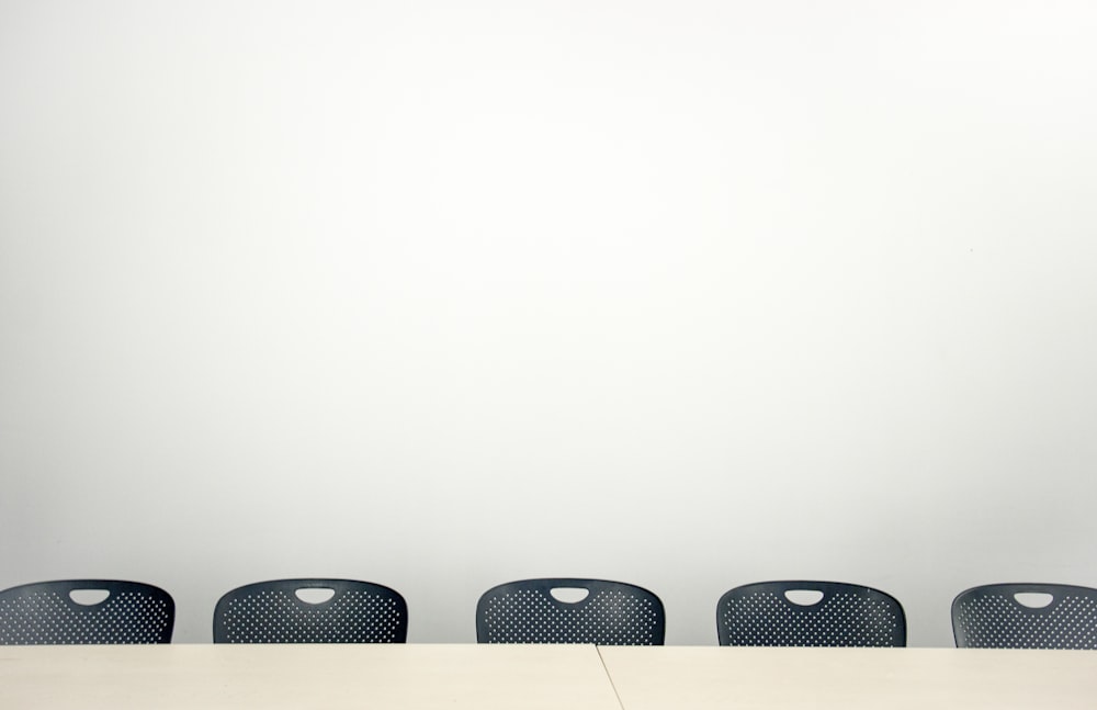 3 black chairs on white room