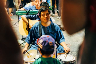 boy in blue and green crew neck shirt playing drum