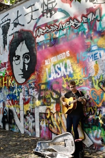 man in black t-shirt playing guitar