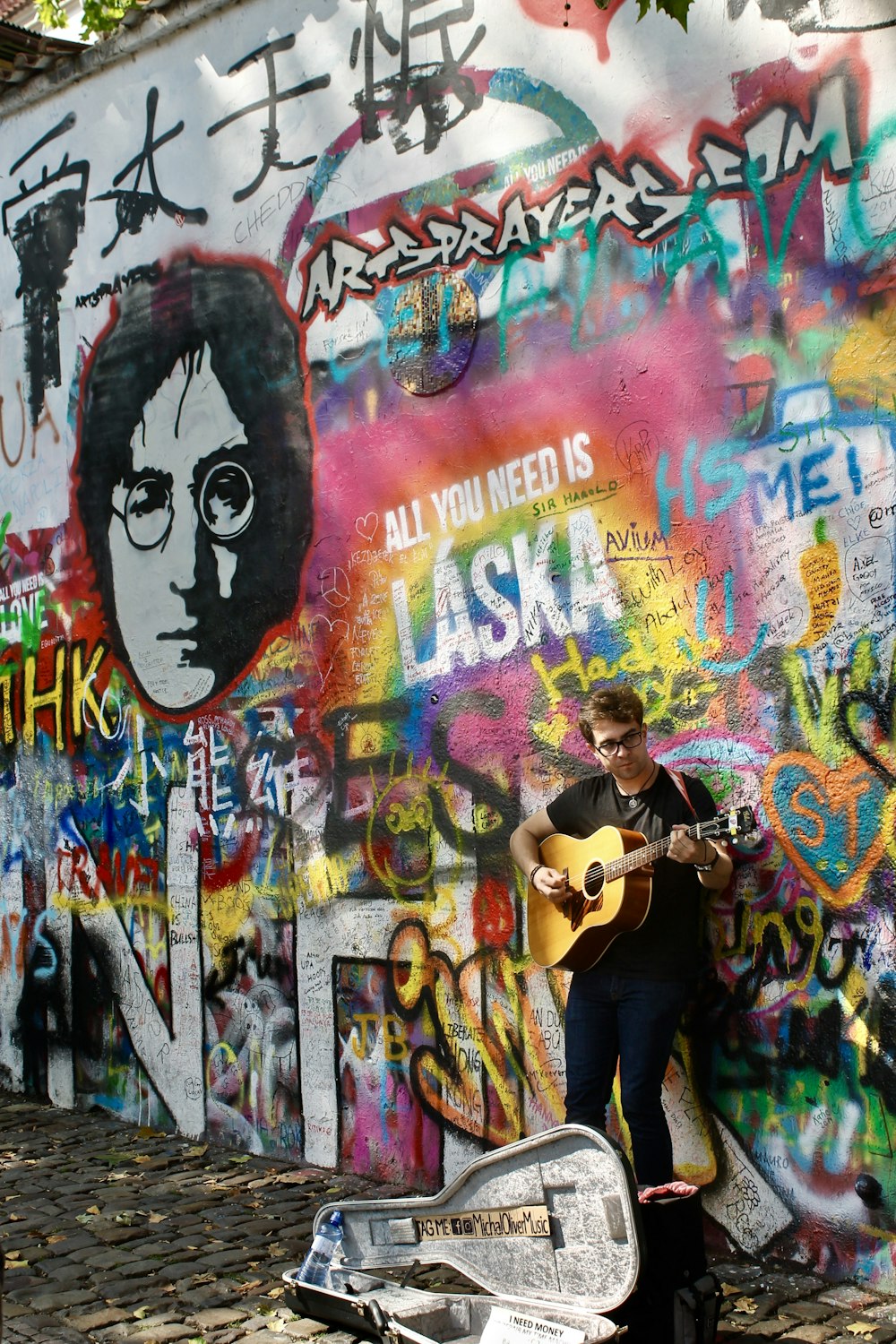 man in black t-shirt playing guitar