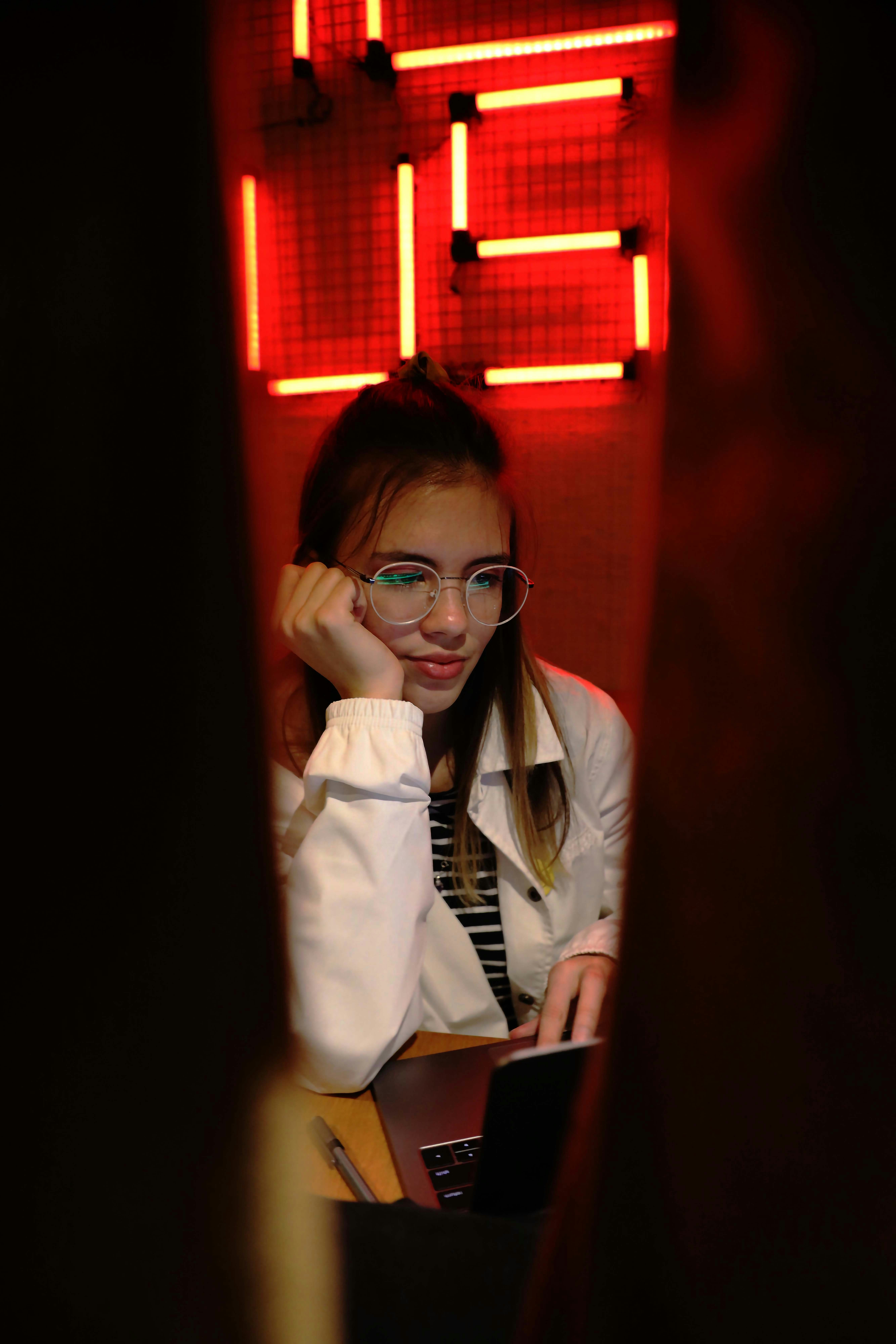 Young woman with glasses looking at laptop with a laptop