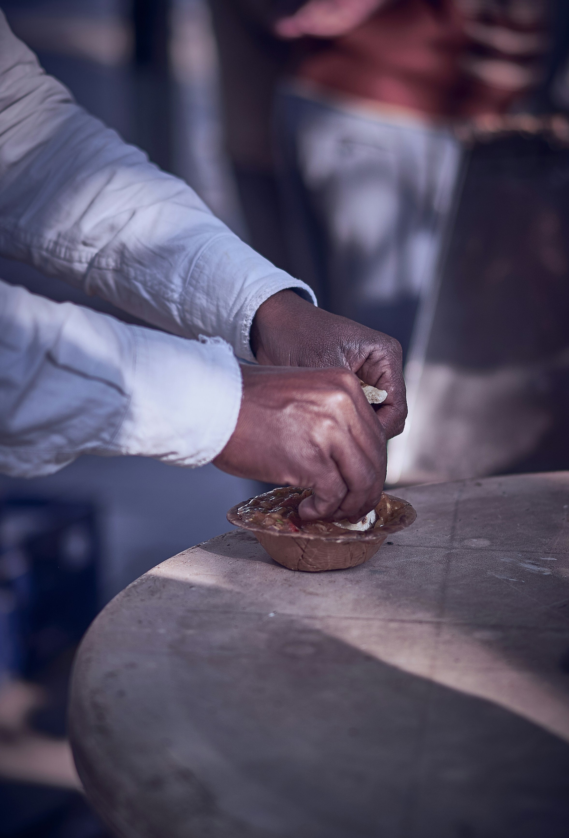 person in white dress shirt holding brown wooden chopping board