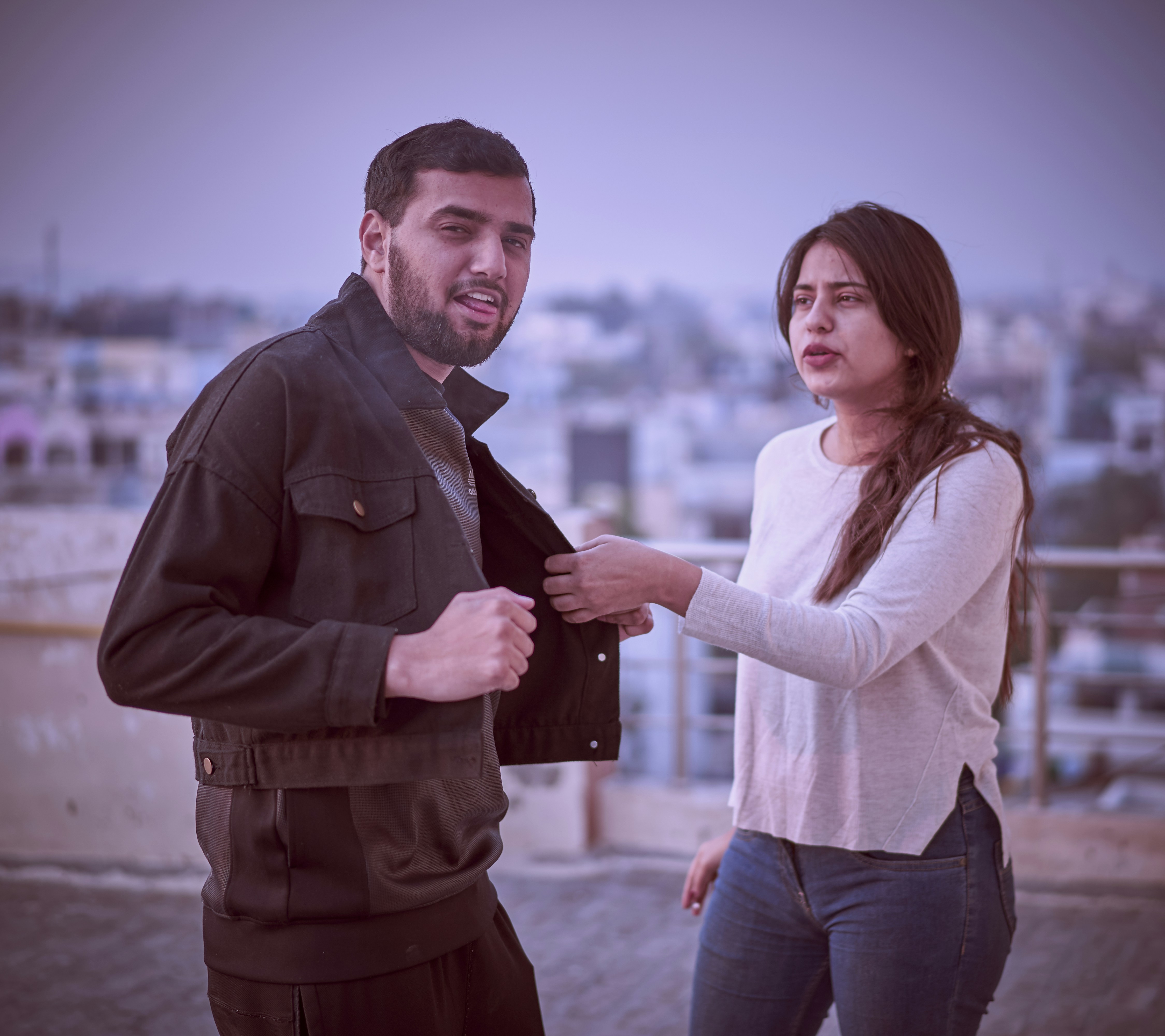 man in gray suit jacket holding woman in white long sleeve shirt during daytime