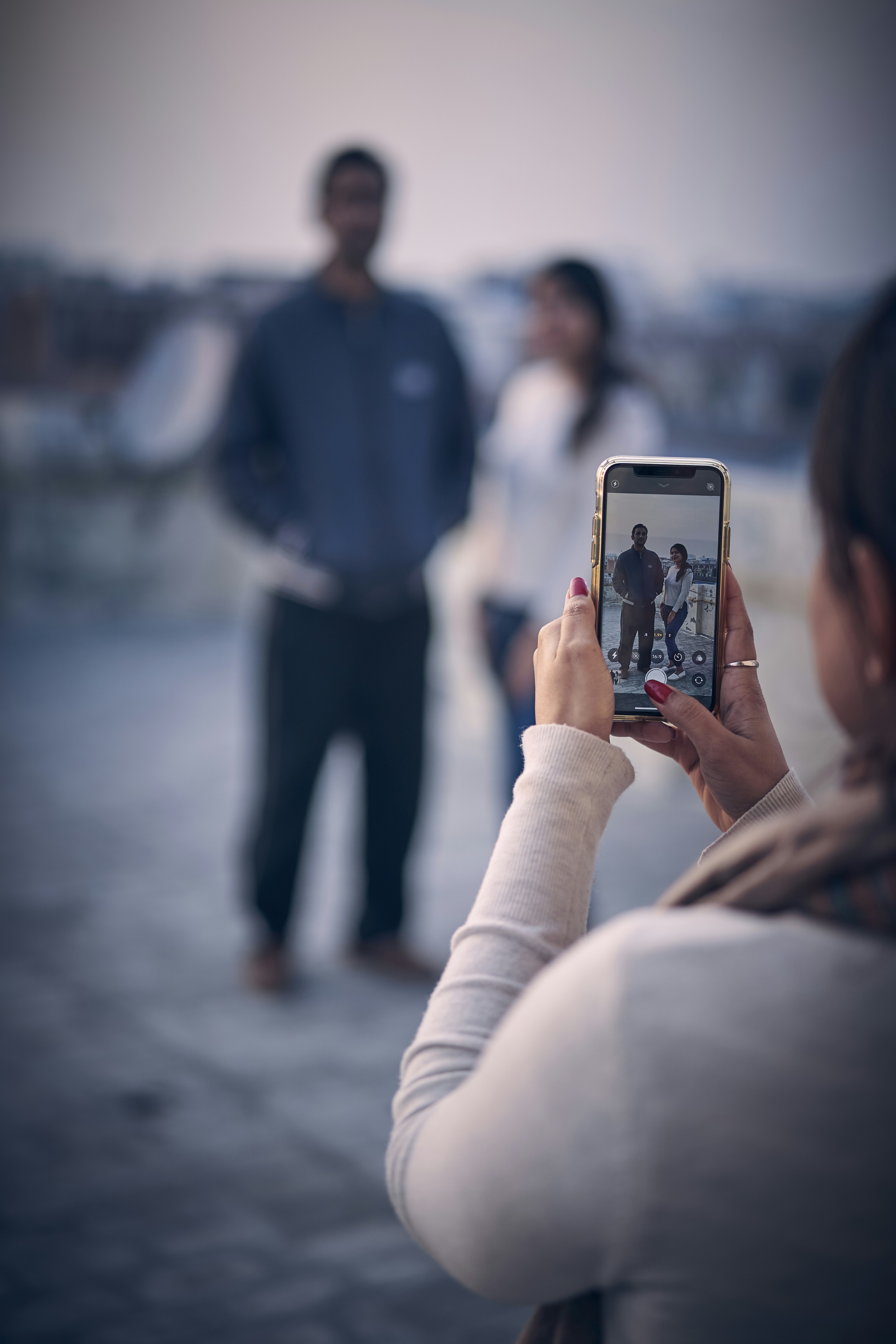 person in blue jacket holding silver iphone 6
